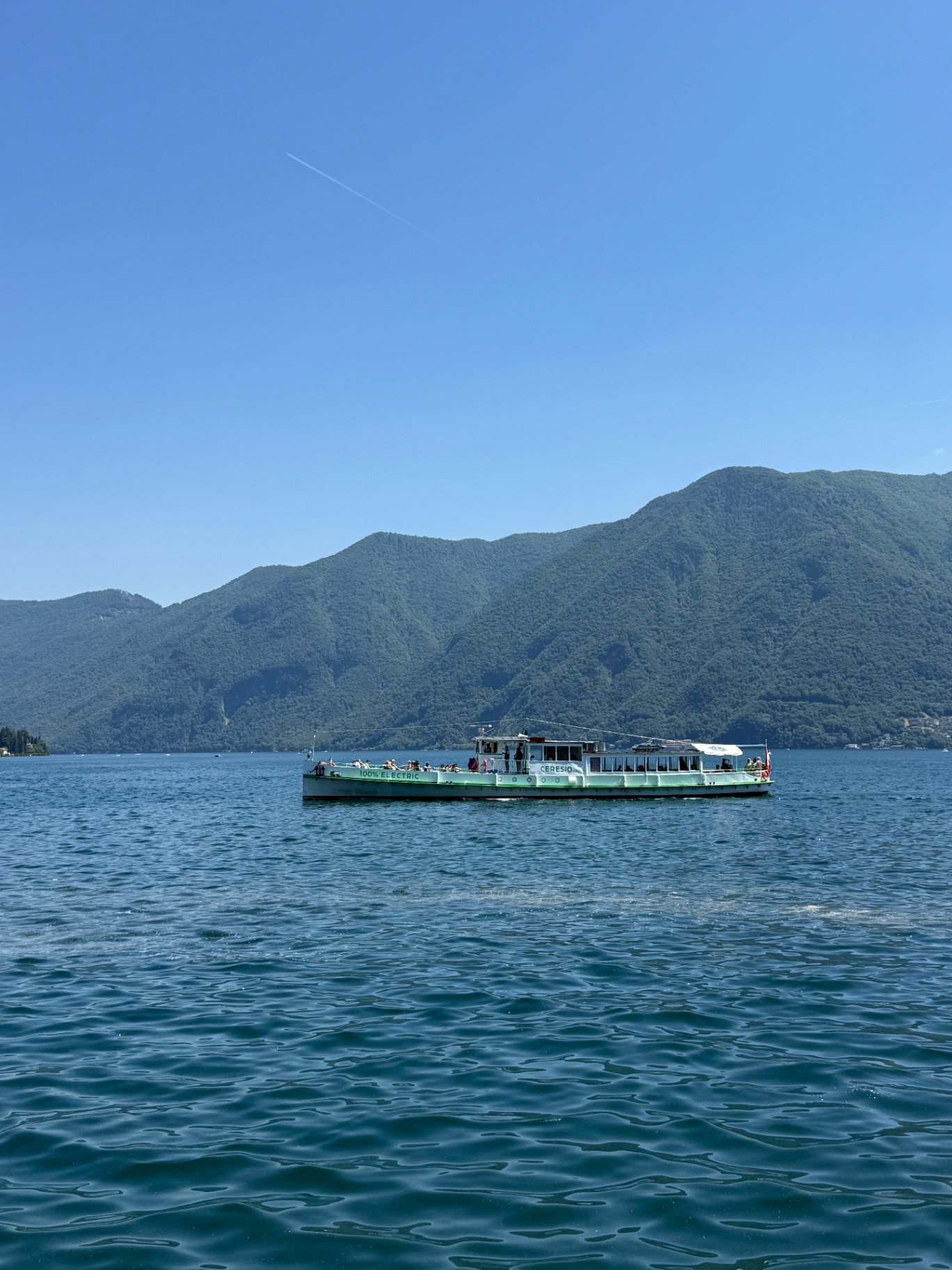 Ausflugsschiff auf dem Luganersee vor bewaldeten Bergen