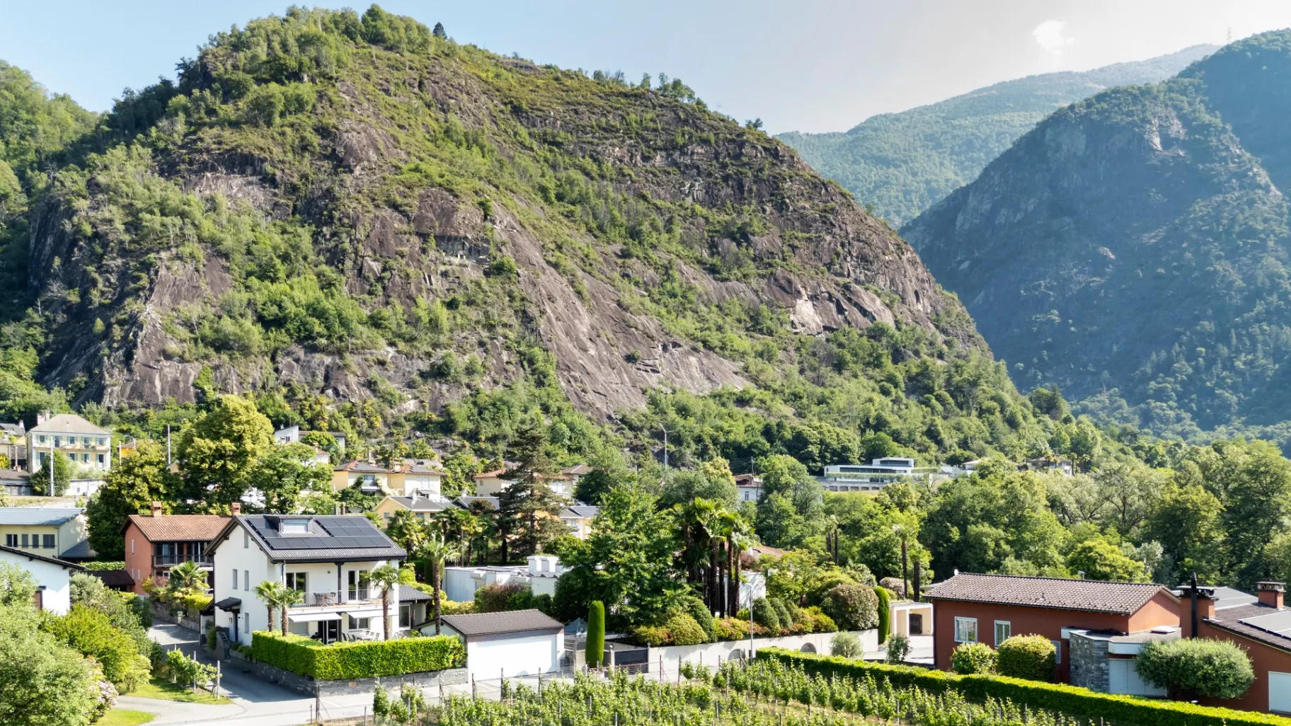 Casa Quattro Fiumi mit Felswand und Weinbergen im Hintergrund