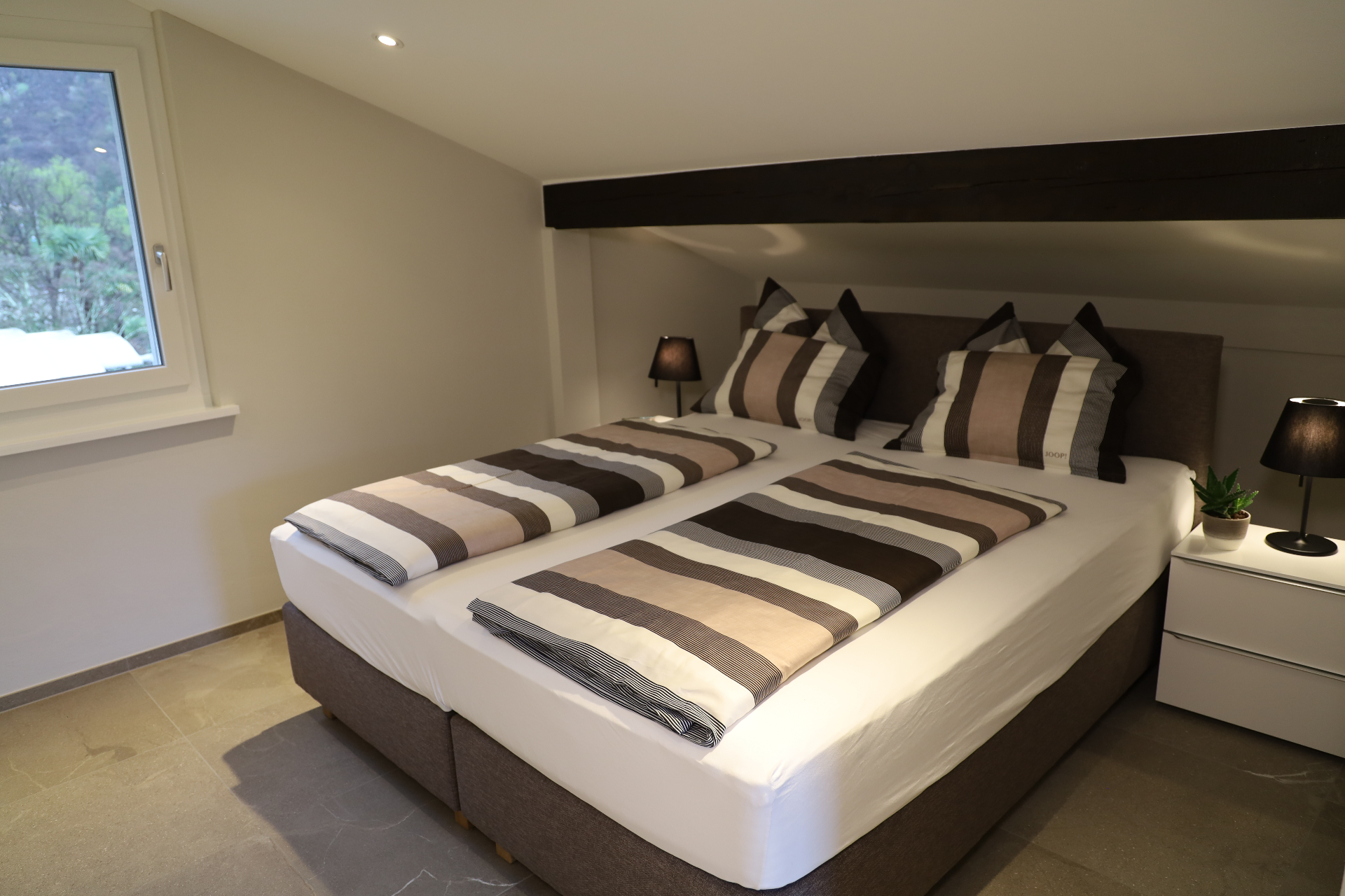Verzasca Schlafzimmer mit Doppelbett unter Dachschräge