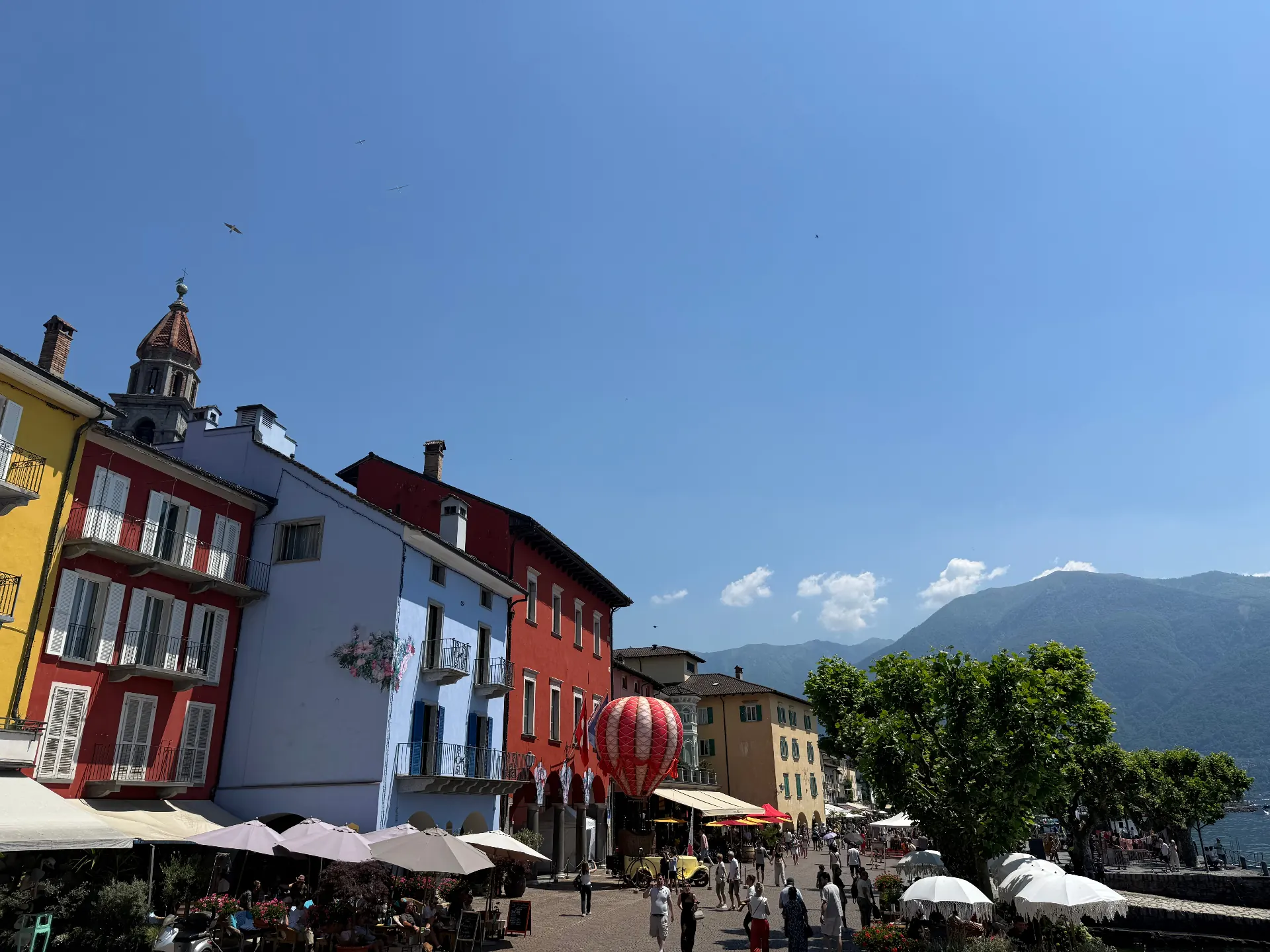 Pastellfarbene Häuser und Kirchturm an der Piazza von Ascona
