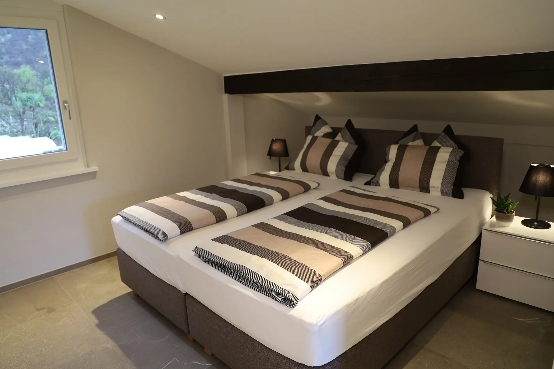 Verzasca Schlafzimmer mit Doppelbett unter Dachschräge