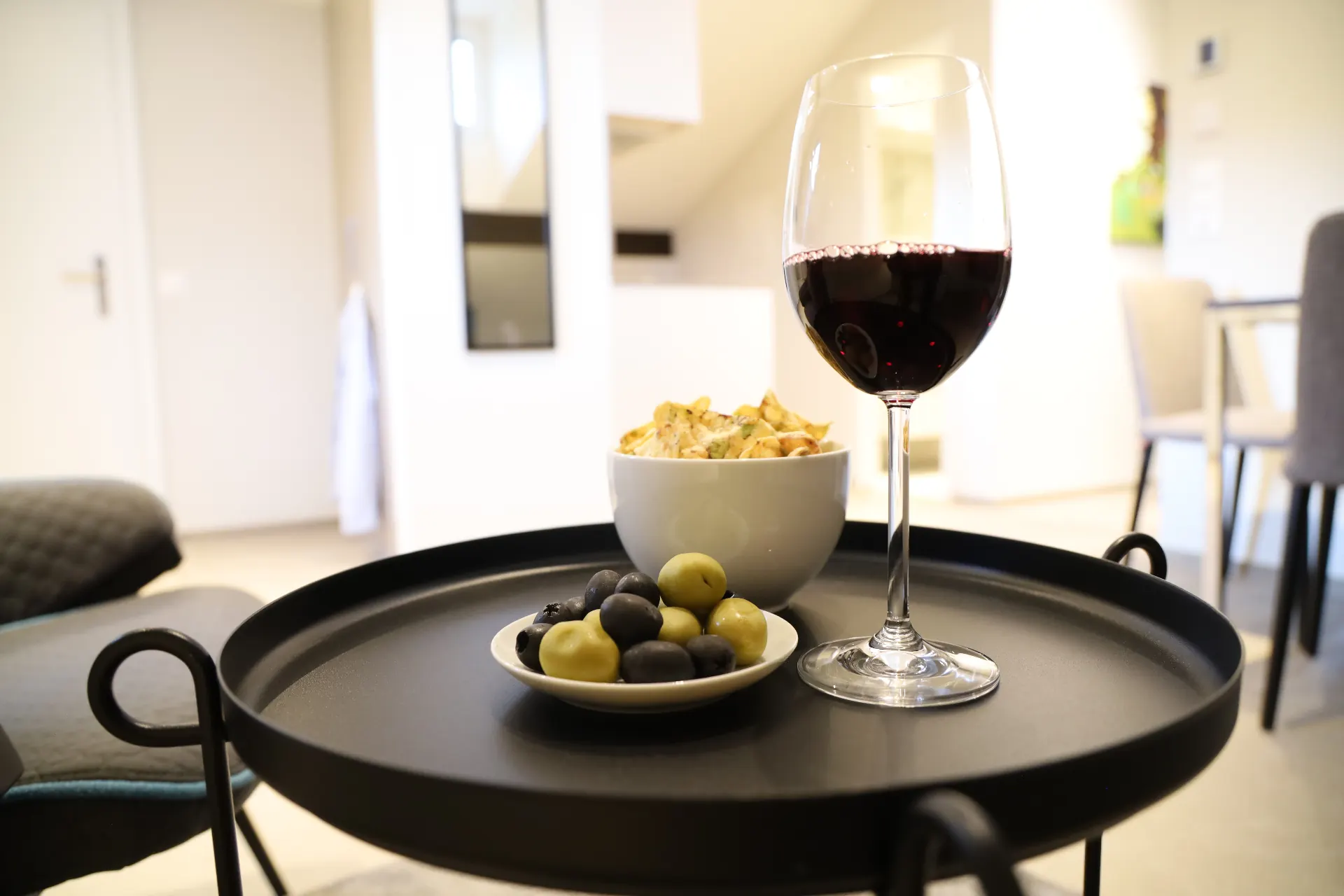 Verzasca Wohndetail mit Weinglas, Oliven und Snacks