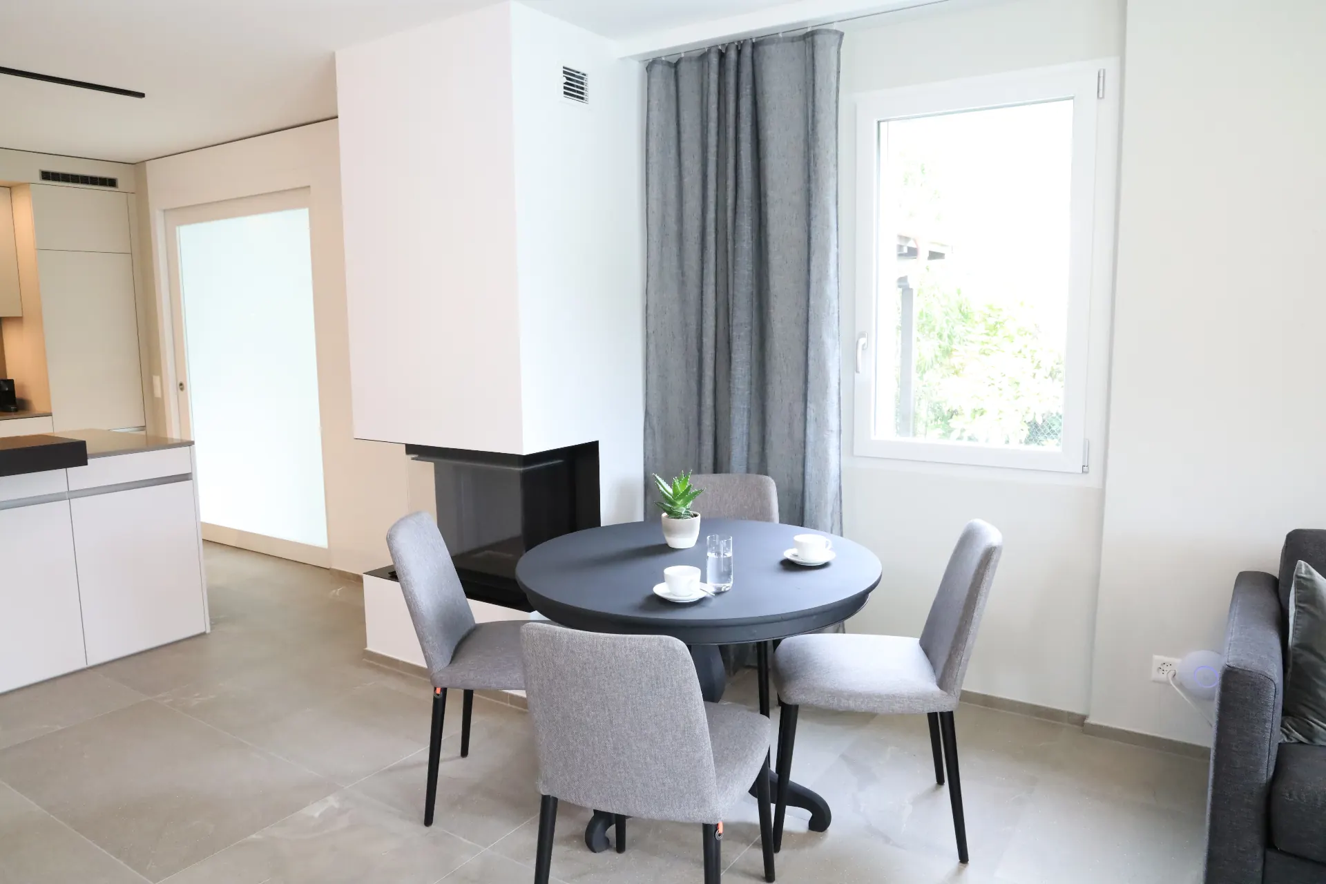 Melezza Essbereich mit rundem Tisch und Cheminée