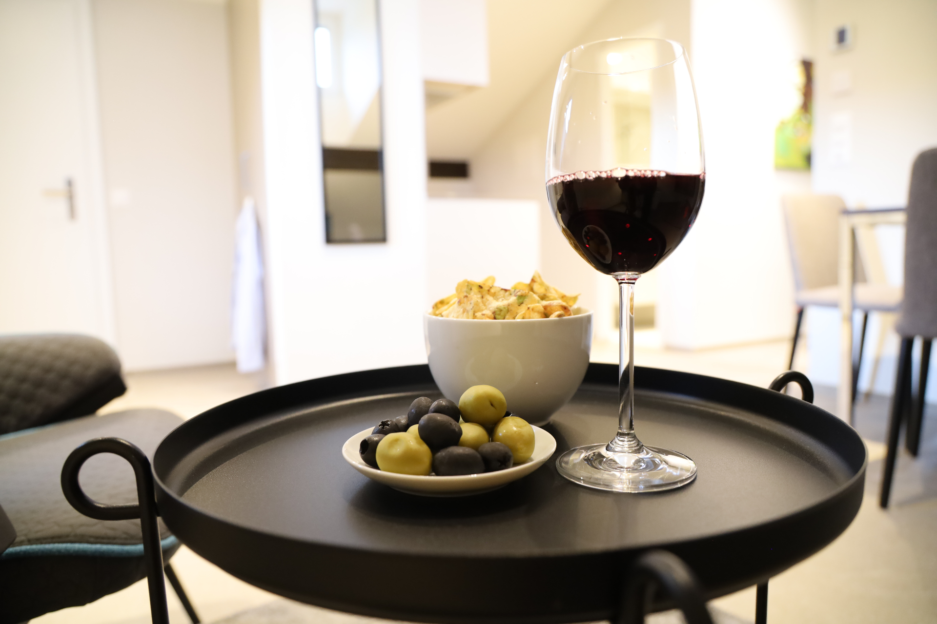Verzasca Wohndetail mit Weinglas, Oliven und Snacks