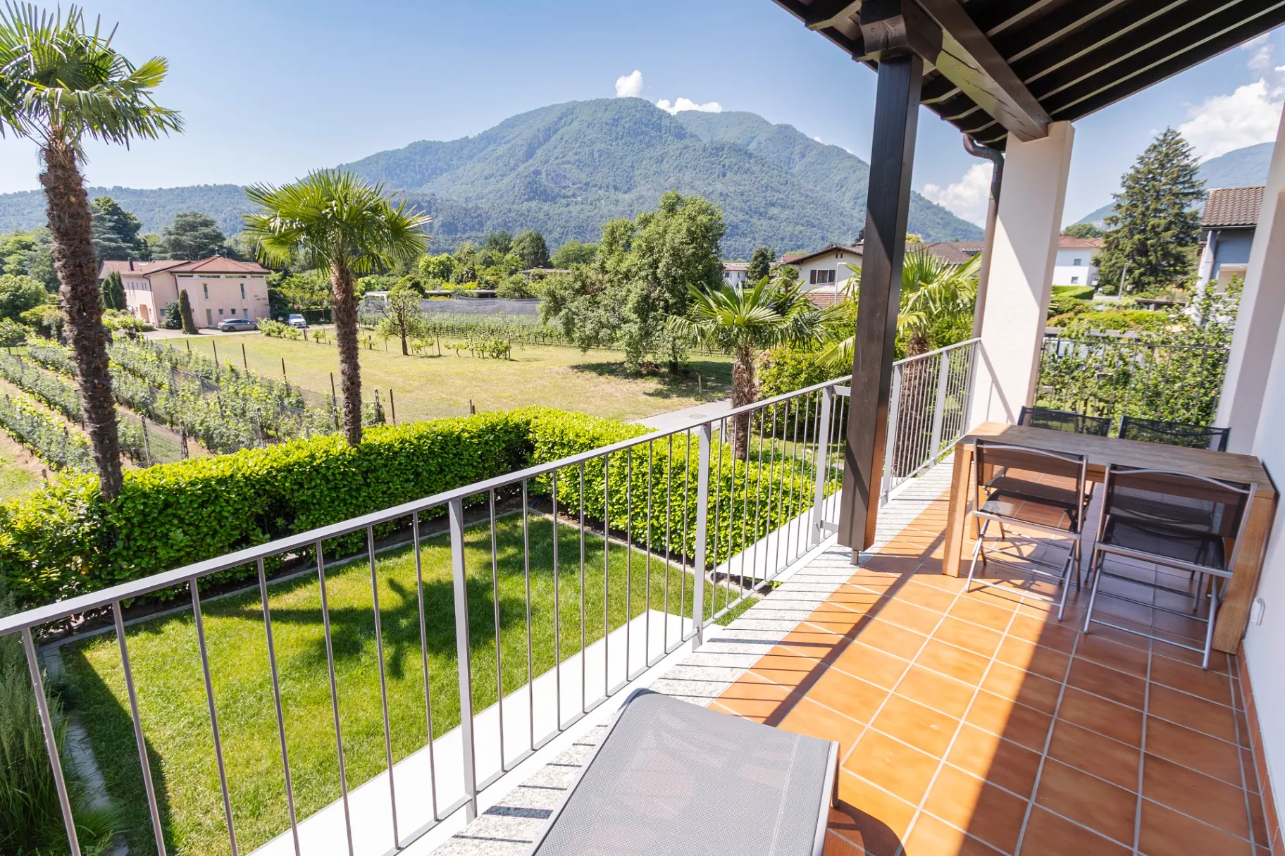Maggia-Balkon im 1. Stock mit Esstisch, Liege und Aussicht auf Reben und Berge