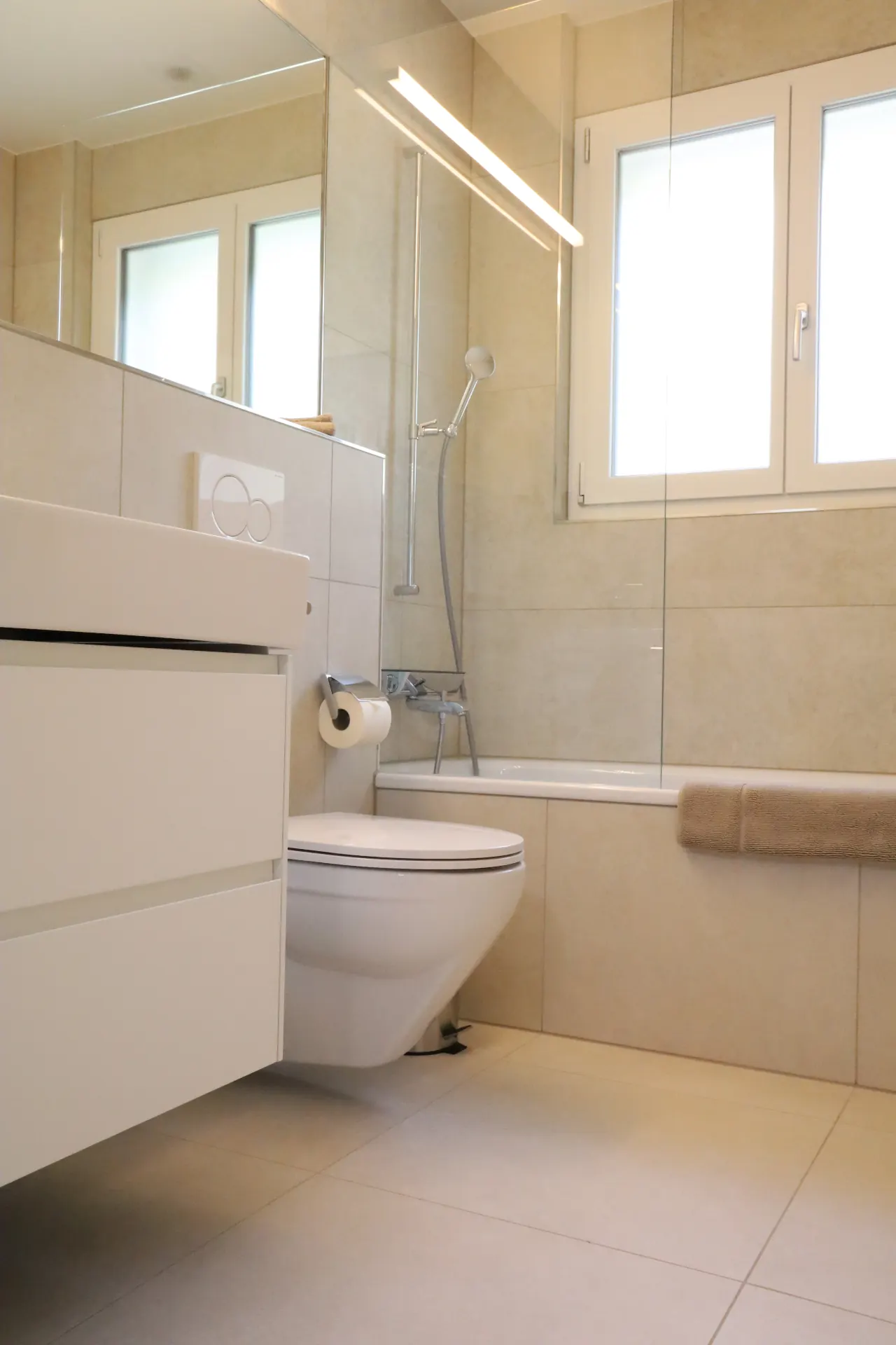 Maggia Badezimmer in Beige mit Badewanne und Spiegelwand